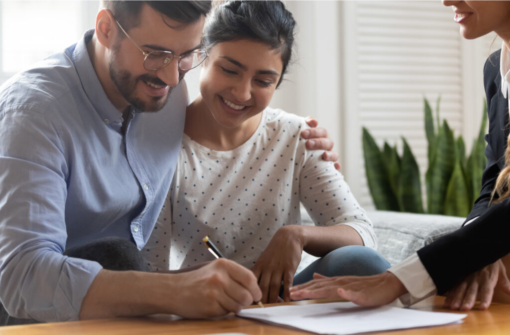 Happy couple sitting together with professional consultant discussing debt repayment programs