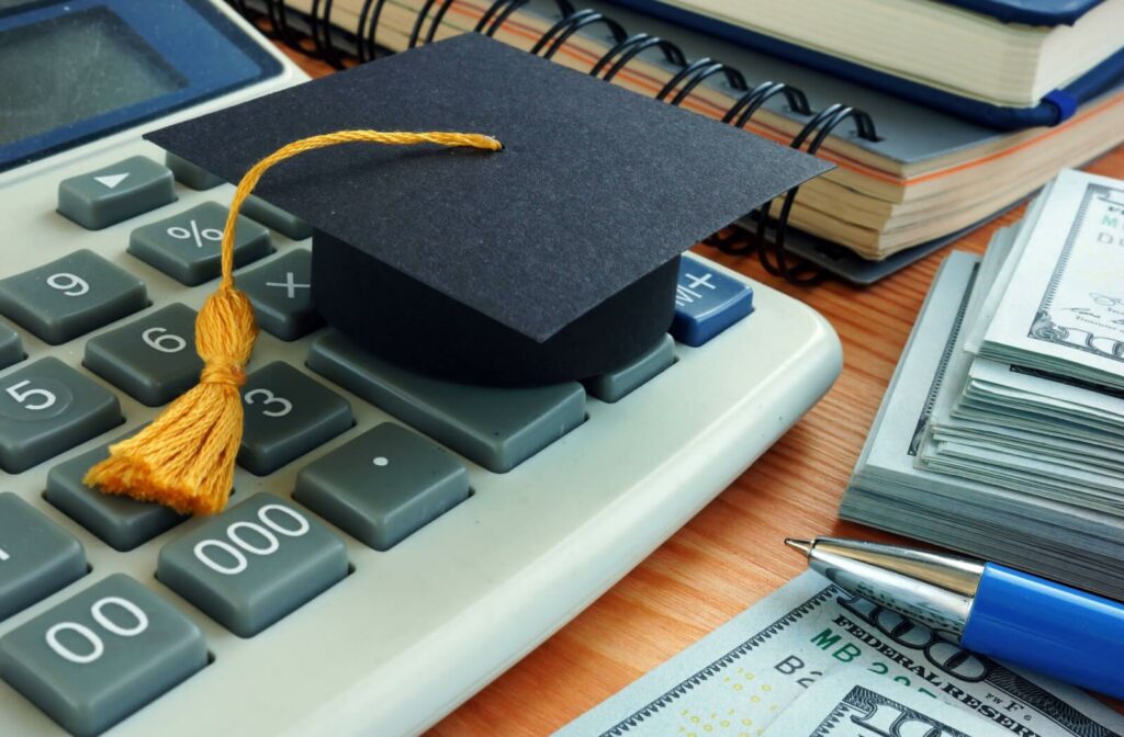 a graduation cap sitting on a calculator