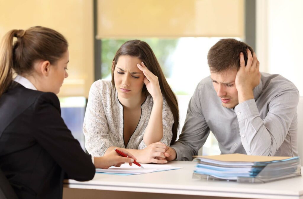 A young couple is consulting a professional financial advisor regarding their financial status.