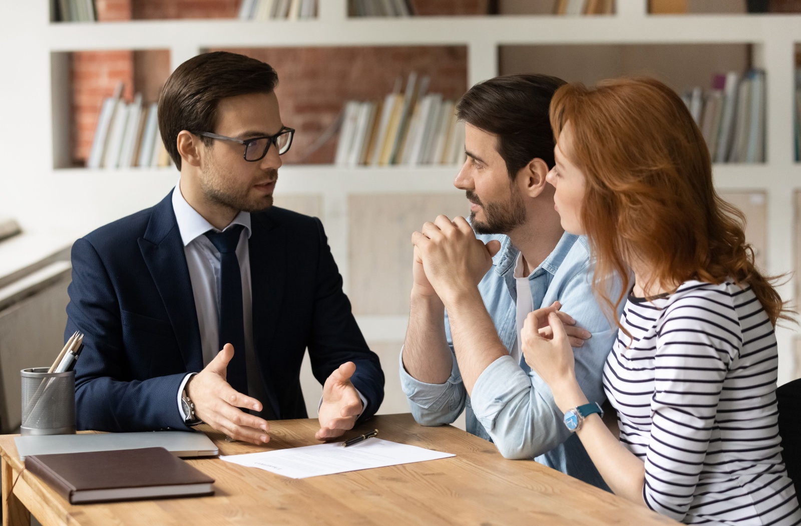 A couple discussing their debt and income ratio with a financial advisor.