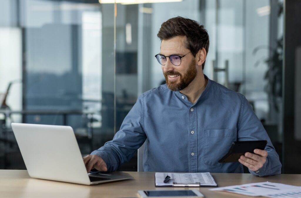 A happy person reviews their finances after handling their debt.