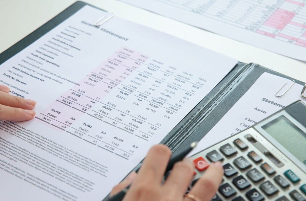 A financial statement on a desk with a calculator beside.